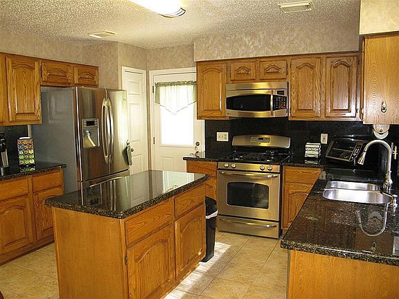 Remodeled island kitchen boasts stainless steel appliances.
