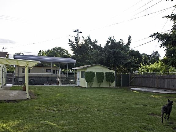 Rear of house with large yard, shop, & seperate gated RV parking