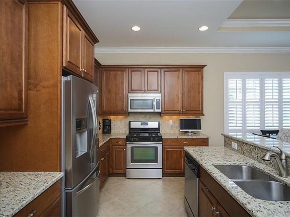 Stunning kitchen with wood cabinets, stainless appliances, granite countertops, tile backsplash and breakfast bar.