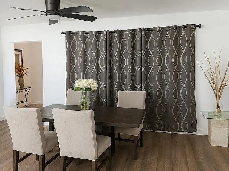 Dedicated dining area with a full-size table for four, ceiling fan, and easy access to adjacent living spaces.