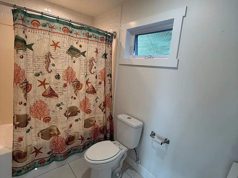 Full bathroom with tub/shower and coastal accents