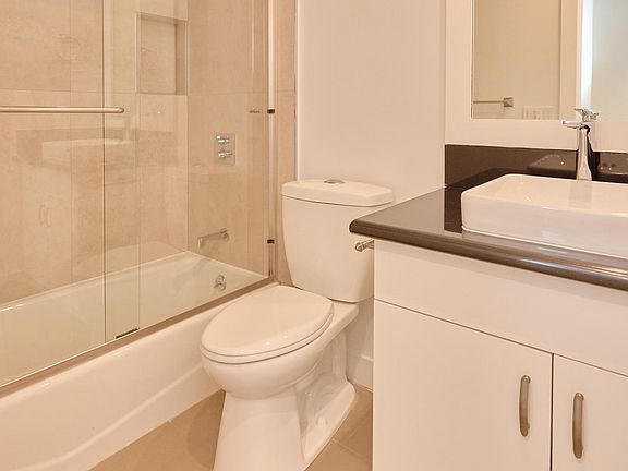 Second Bathroom with quartz counters, custom cabinets, designer tile and tub/shower combo with glass enclosure