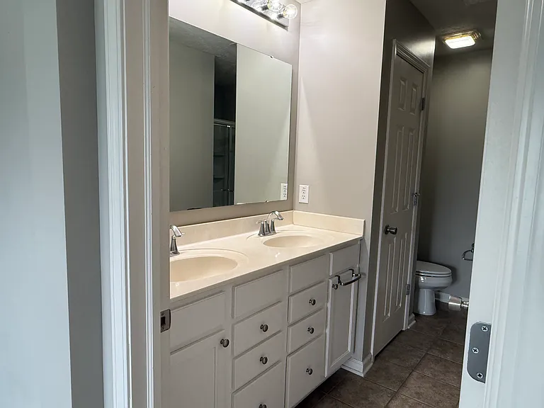 The en suite bathroom has double sinks and another great storage closet.