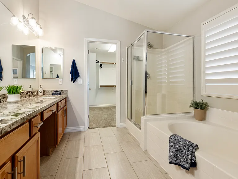 Primary bath with 2 sinks, large counter, shower, garden tub and walk in closet