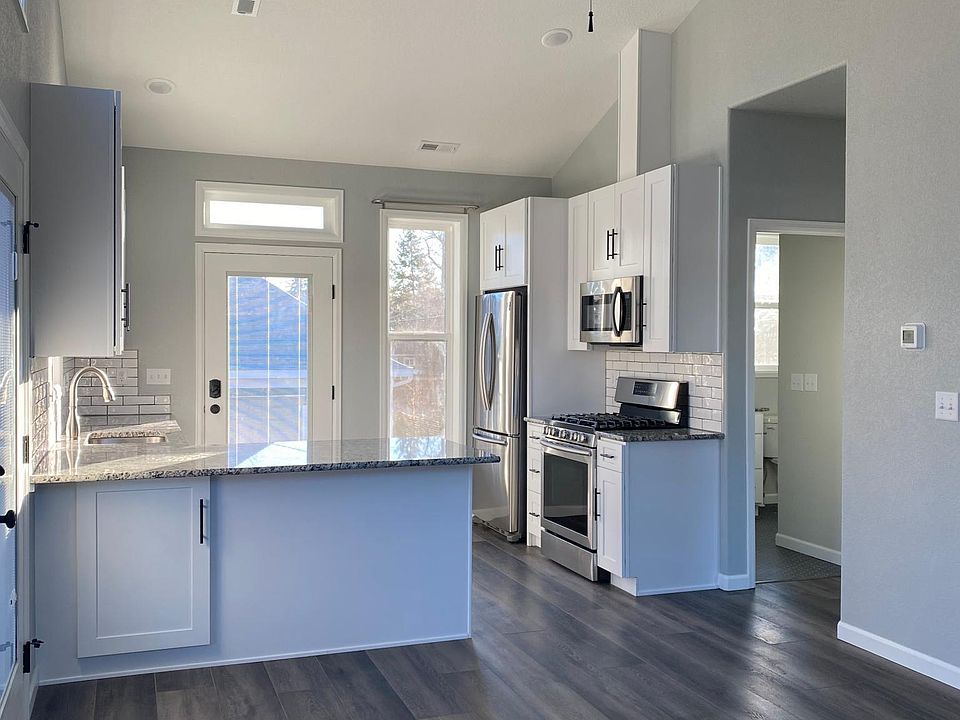 Open concept living area and kitchen with peninsula countertop and recessed lighting.