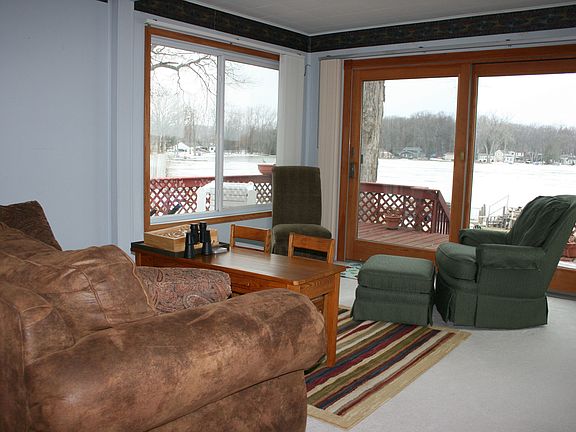 Living room with large windows on two sides and large sliding door to deck