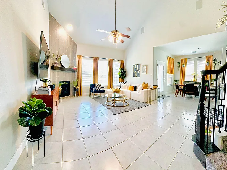 Open-concept living area with vaulted ceilings, large windows, and a defined dining space beside the seating area.