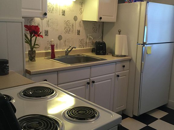This kitchen is fully stocked with dishes, glassware, silverware and pots and pans.