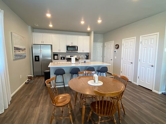The dining area. The three doors on the right are the pantry, storage area and half bath. The garage door is at the end.
