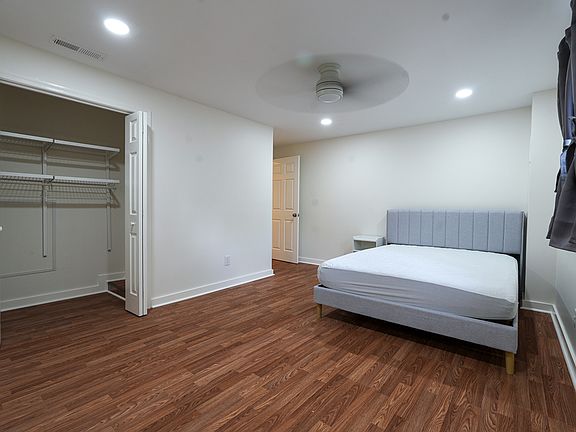Bright, furnished bedroom with large closet including adjustable shelving options.