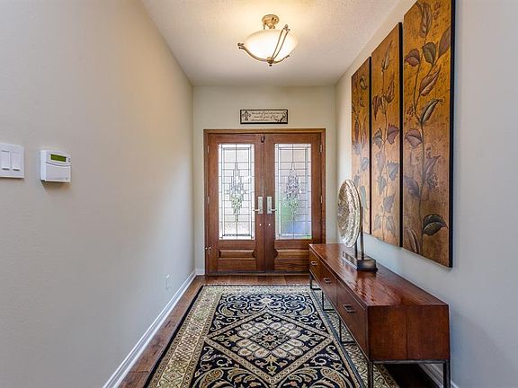 The entry is spacious, light and bright, and boasts engineered hardwood flooring that runs through the main living areas of this home.