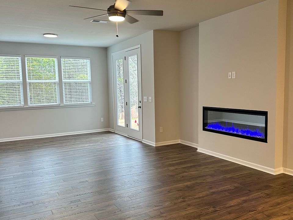 Open concept living room with sun room leading to outdoor patio.