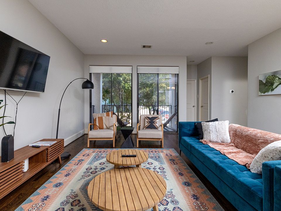Spacious living room with couch, 2 chairs and flat screen TV