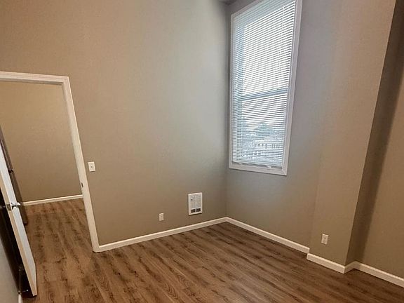 Bright room with elegant wood flooring and a large window, perfect for natural light. Bright room with elegant wood flooring and a large window, perfect for natural light.