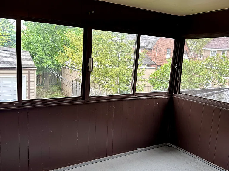Enclosed three-season porch, perfect for relaxing, reading, or enjoying extra living space.
