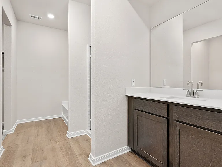 The master bathroom has a sprawling vanity, glass walk-in shower and a garden tub.