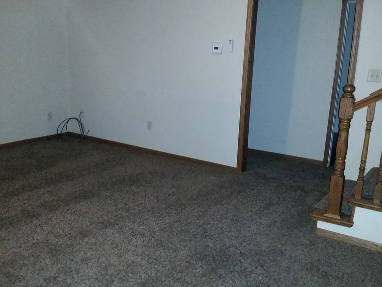 Living room, open stairway leads to upper level with bedroom, sitting area, and large bathroom... door way leads to hall with 2 bedrooms and main floor bathroom