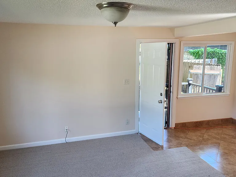 Front Room facing side door and kitchen nook and closet with washer and dryer hookups