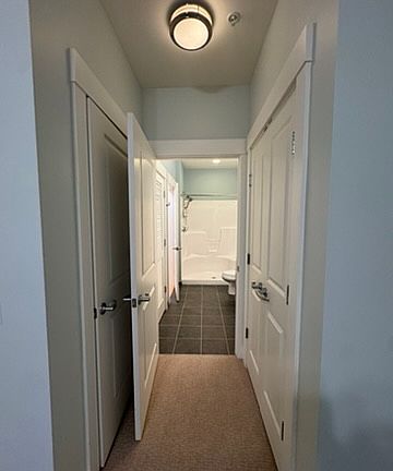 From the second bedroom, looking at the bath, with the closet on the right, and utility closet on the left.