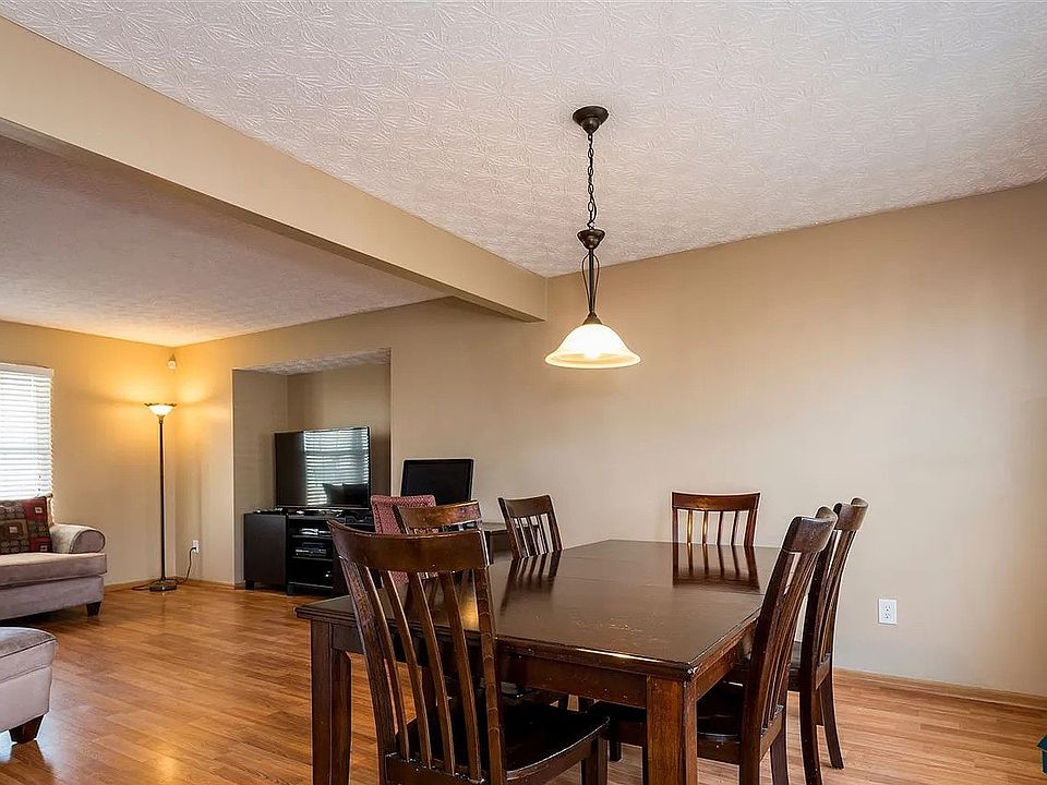 Open dining area with hardwood flooring, neutral wall colors, and modern overhead lighting.