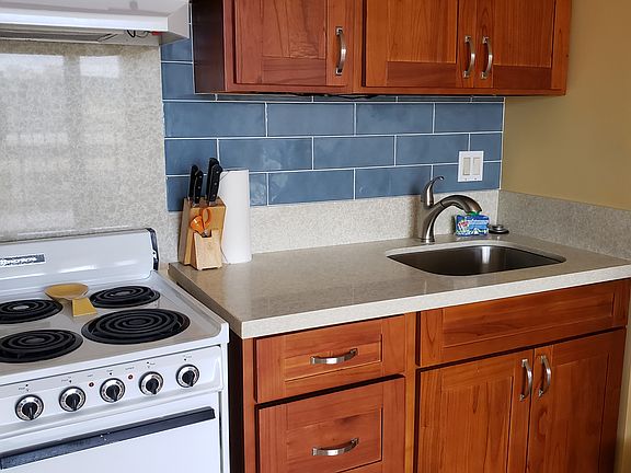 4 Burner Stove / Oven with typical large stainless sink and Natural stone counter tops