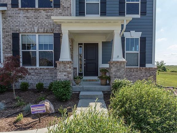 Covered front porch, and pretty landscaping.