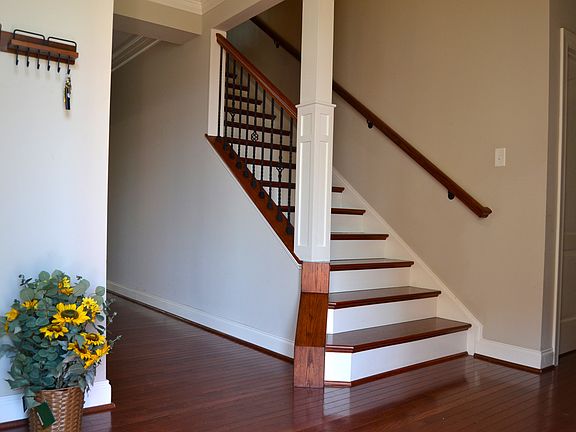 Dramatic 2-story entrance foyer with half bath and laundry room on one side and a beautiful office with hardwood flooring, an upgraded lighting fixture, a bay window and Plantation Shutters.