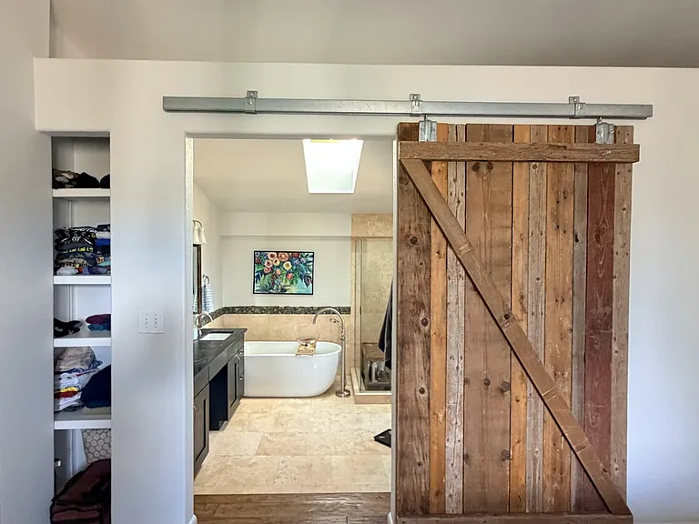 Master bedroom barn door leading to master bathroom that hold walk-in closet