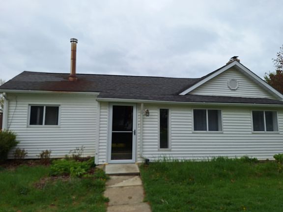 side of house from driveway - storm door opens to 3 season room which leads to entry door to kitchen