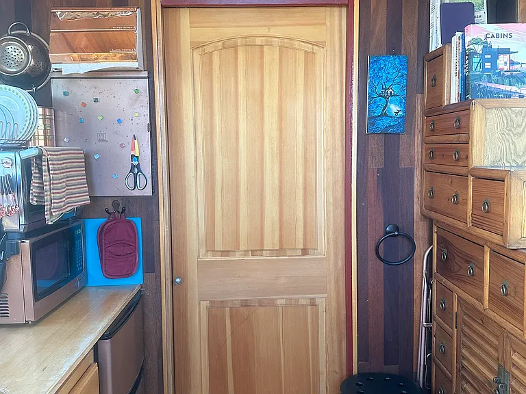 The pocket door separates the bathroom/entryway from the rest of the house. A storage loft above is a great place to tuck things away that aren't needed every day.