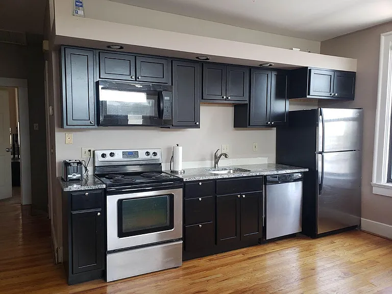 Updated kitchen with black cabinets with granite tops & stainless appliances with microwave over the range