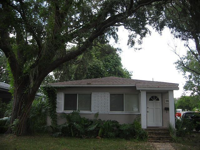 Front view with mature oak tree, large picture windows