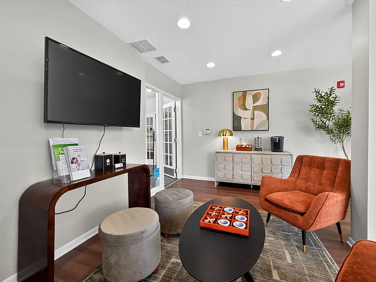 Relax and unwind in the community clubhouse featuring a cozy fireplace and TV at Renaissance at Carol Stream in Carol Stream, IL.