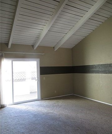 Living room with vaulted ceiling opens to private patio