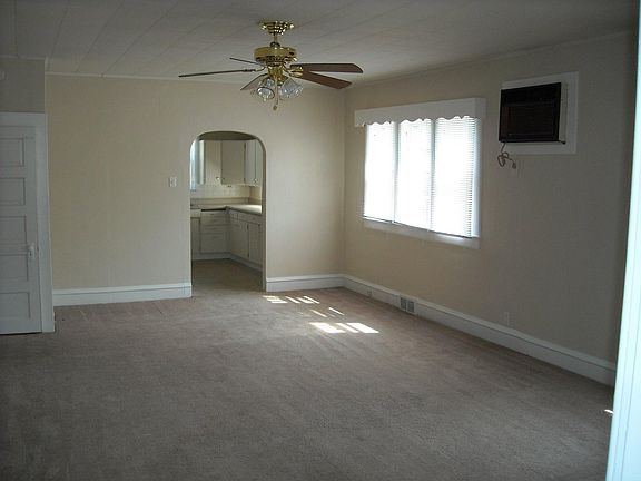 Living room has air conditioner unit installed in wall to leave windows free to open.