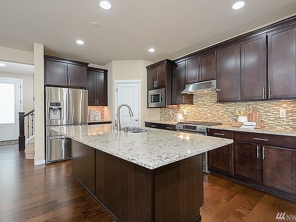 Gorgeous Chef's kitchen with walk-in pantry, featuring a large center island Quartz slab counters , full height designer tile backsplash and undermont lighting. 