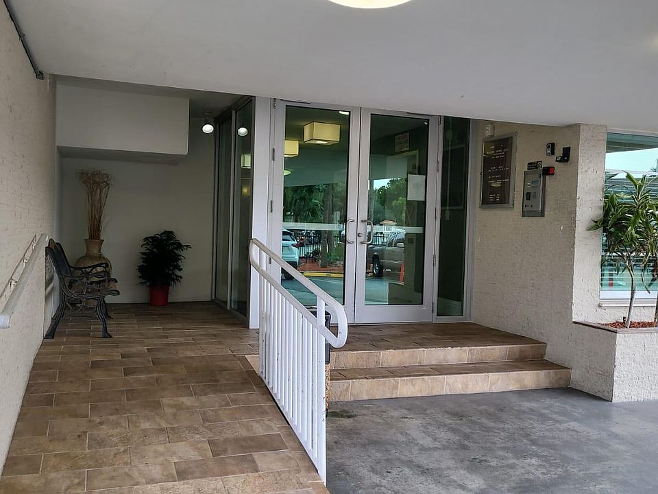 The building entrance is covered with a canopy and equipped with handicapped-access ramp and railings.