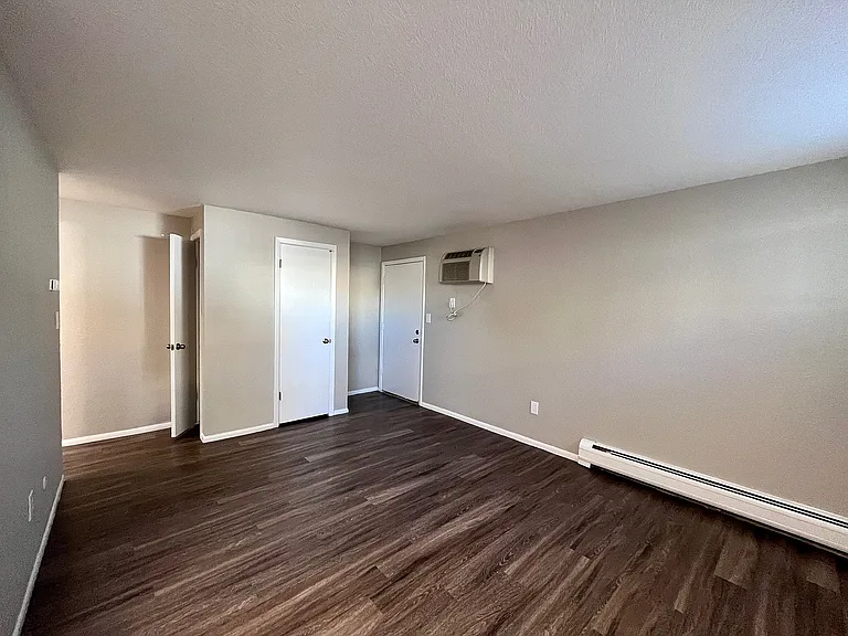 Bright, spacious room with elegant hardwood flooring and freshly painted walls, ideal for a modern living area.