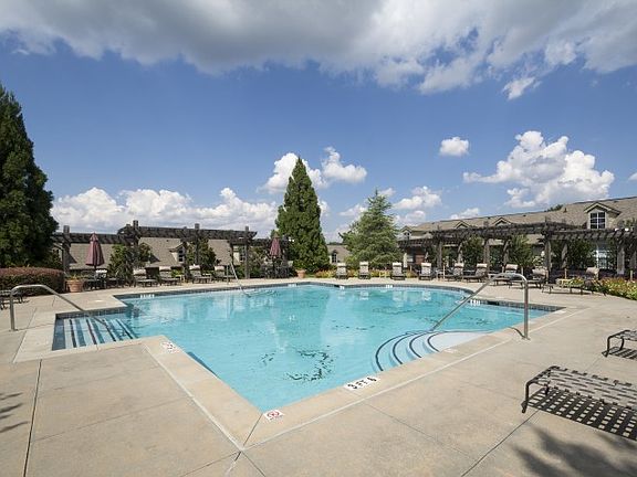 Serene poolside views with shaded pergolas and lounge seating