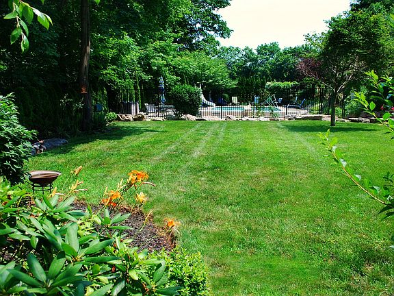 Lush great lawn at side of house between patio and pool.  One of 4 lawns areas