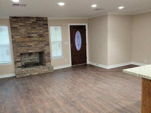 Living Room features wood burning fireplace, new windows, vinyl plank flooring, LED flush mount lighting