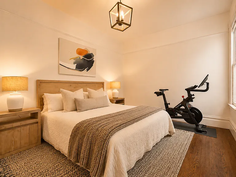 Bedroom #3: Beautifully furnished with a premium king bed and Peloton, overlooking lush garden foliage with a charming peekaboo view of the iconic Transamerica Pyramid. Ample closet space provides abundant storage, a rarity in San Francisco homes.