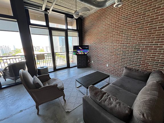 25' brick wall gives NY loft vibes in this 1BR unit....boxes behind the couch so I didn't shoot the entire thing. :)