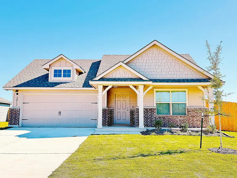 Brand-new Craftsman-style exterior with a covered front porch and fresh landscaping.