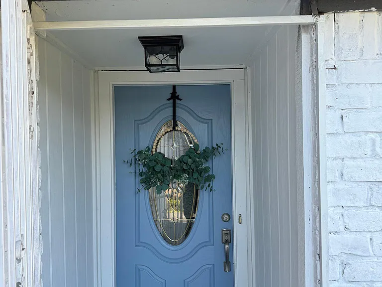 Front entrance features blue front door, with newly installed black light fixture. Gated front entrance.