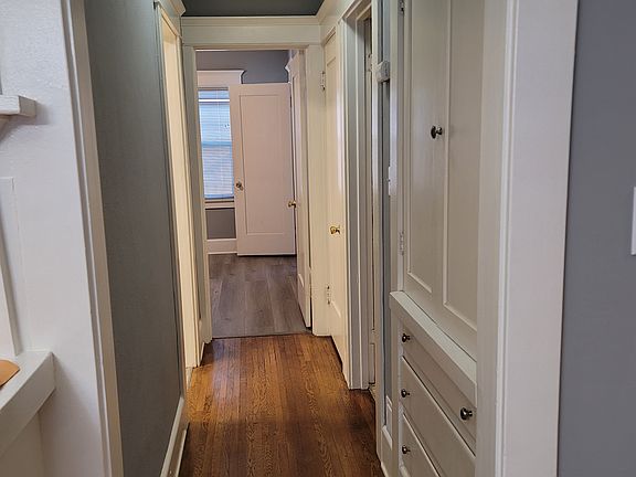 Looking down the hallway into bedroom. Built-ins on the right side.