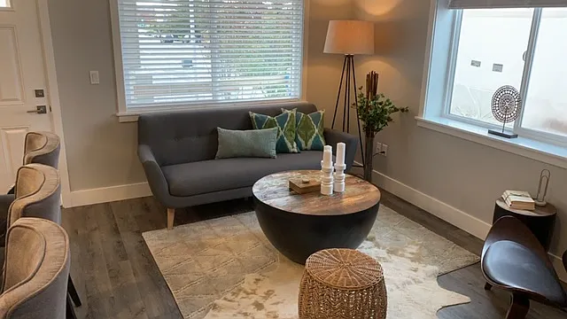 Living Room area with large window, cordless blinds and all white mill work around the windows and floor.
