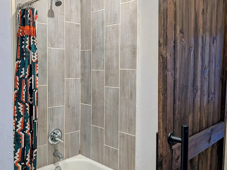 Bathroom with full tub and tiled shower.