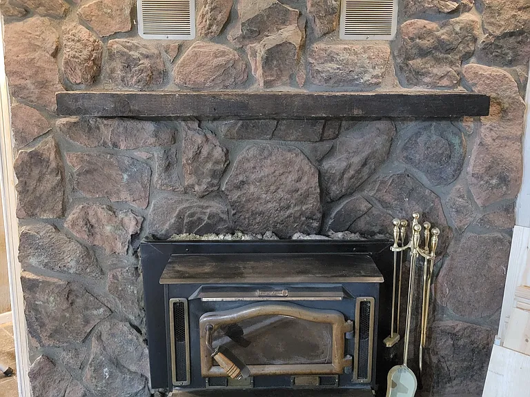 Downstairs fully functional wood burning stove with blower for heat retention and mantle.
