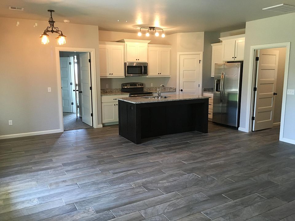 Kitchen with island and spacious refrigerator, utility room to the left and entrance to garage